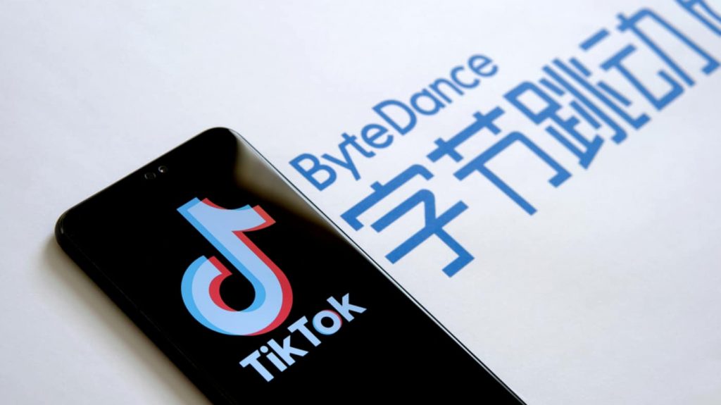 Celular com logotipo do TikTok na tela em cima do logotipo da ByteDance